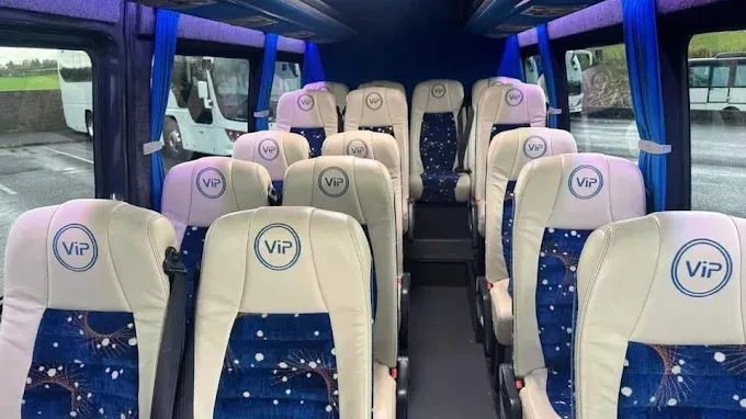 Inside a bus: rows of seats with curtains at the windows