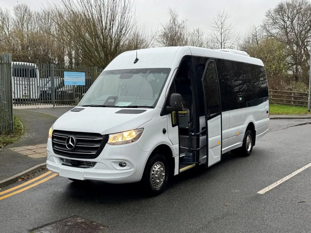 A white Mercedes Sprinter minibus with its passenger door open