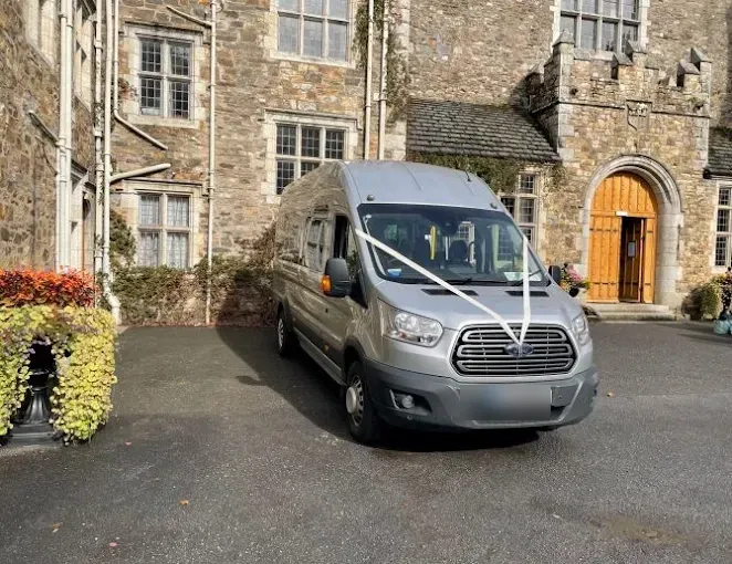 A silver minibus with wedding ribbons outside Cloughjordan House